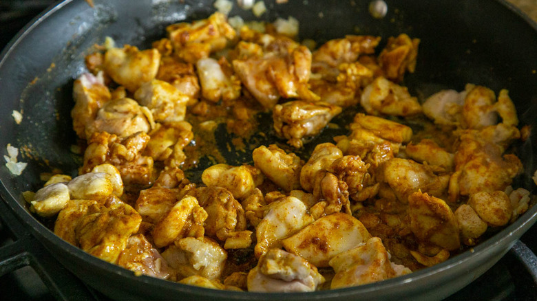 chicken pieces browning in skillet