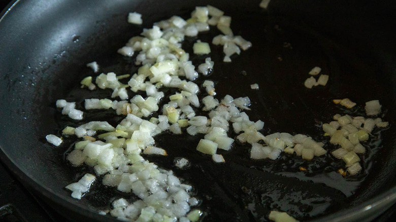 diced onions frying in skillet