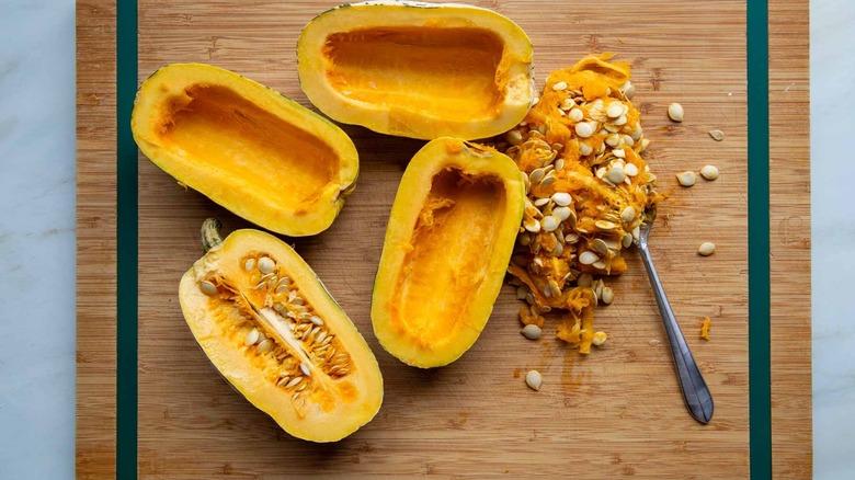 scooping out seeds and membranes of delicata squash