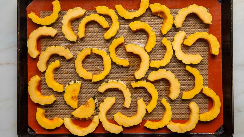 delicata squash slices on baking sheet