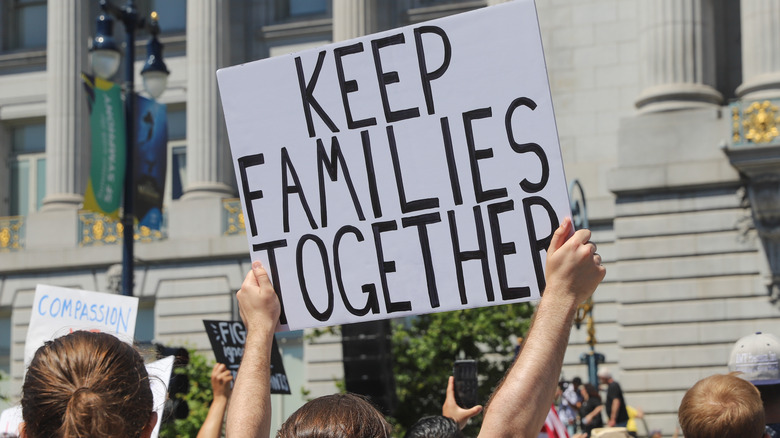 Protester holding up a "Keep Families Together" Sign at a rally