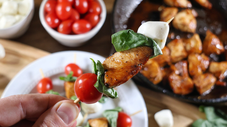 hand holding Margherita chicken skewer