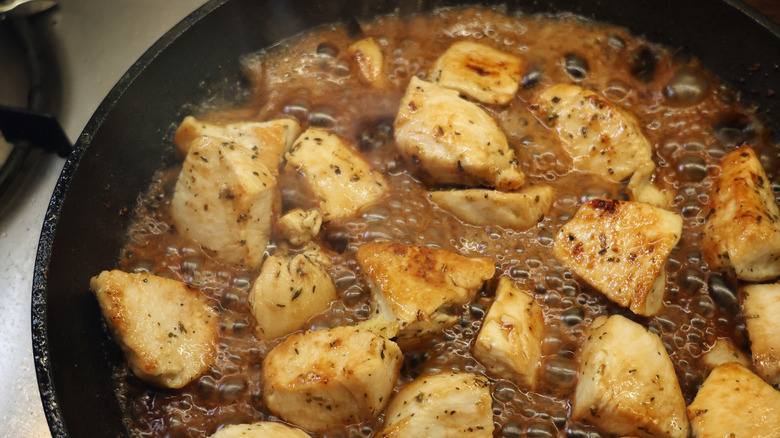 skillet full of chicken breast and bubbling balsamic vinegar