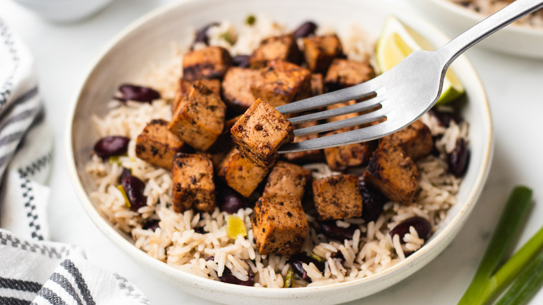 Jerk tofu forked out of bowl