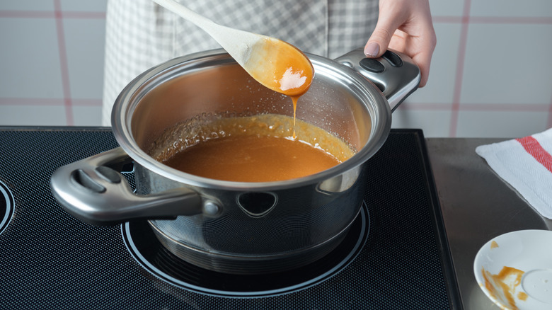 stirring caramel on stove, pot of caramel