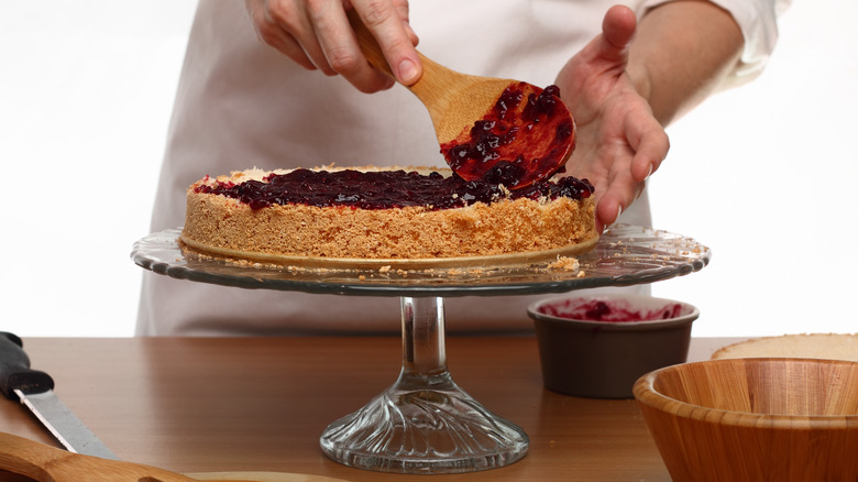 chef spread jam on a cake layer