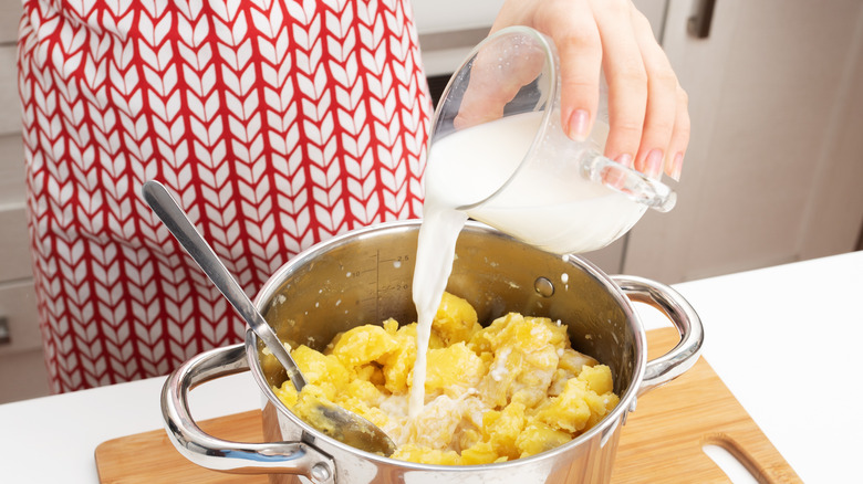 Pouring milk into potatoes