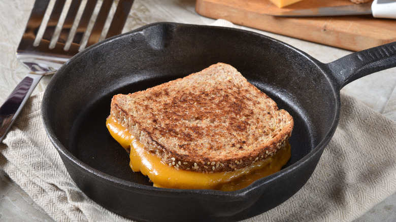 Grilled cheese on cast iron skillet next to spatula