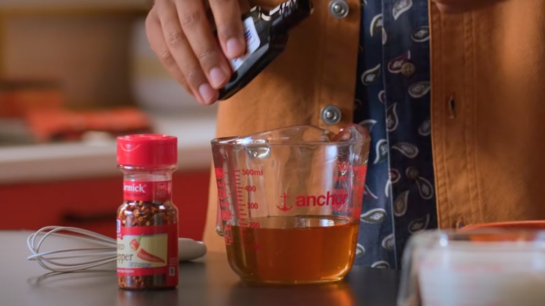 hand pouring vanilla extract