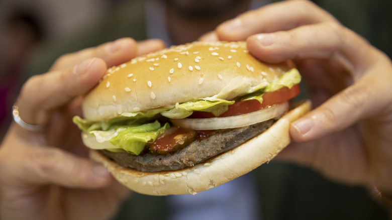 Person holding Burger King Whopper