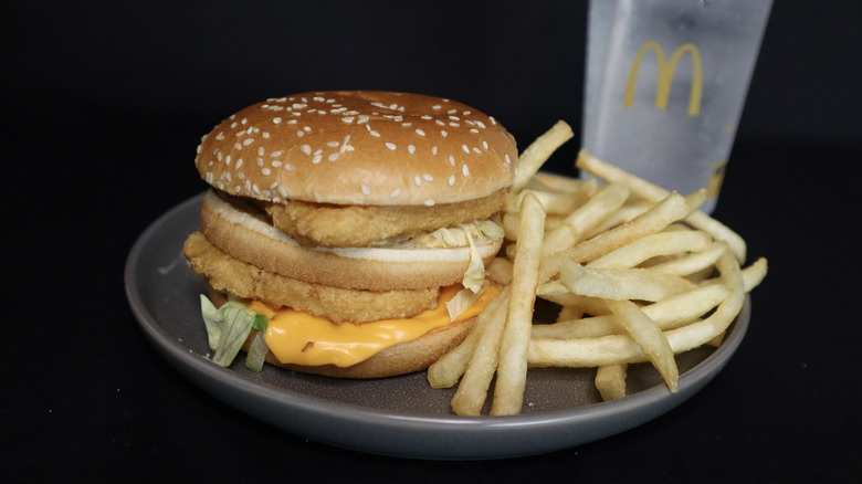 chicken Big Mac on plate with fries, drink in background