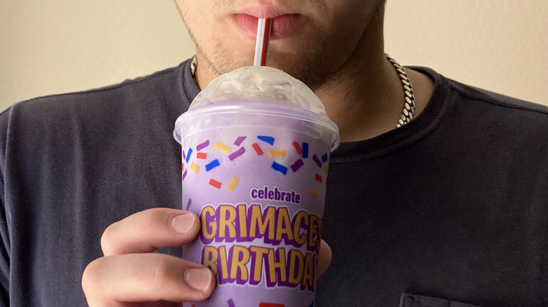 man sipping grimace shake