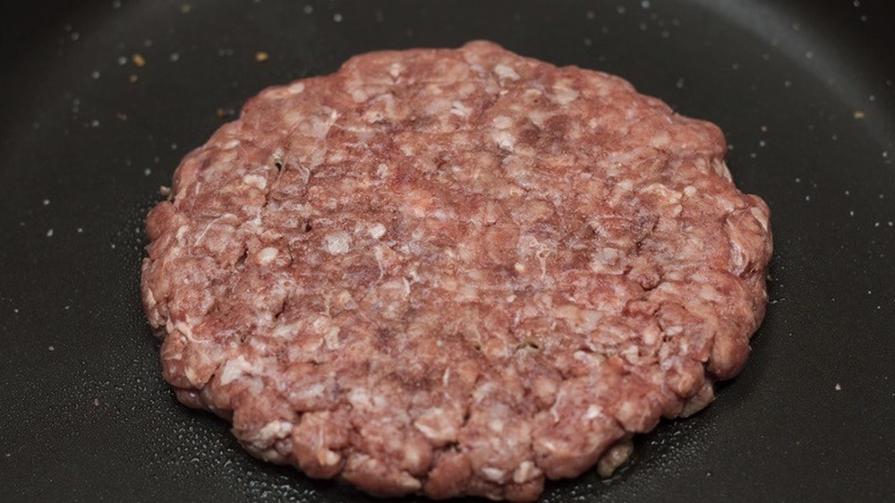 A burger patty in a skillet for McDonald's Hamburger copycat recipe