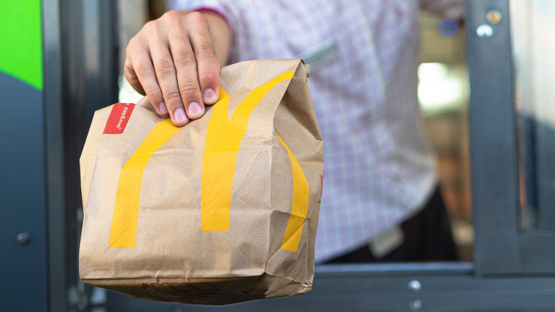 Worker hands out food from drive thru