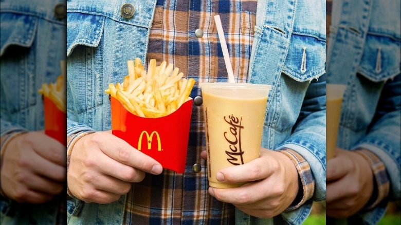 Person holding McDonald's iced coffee and fries