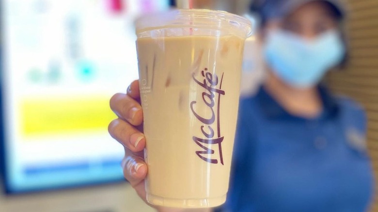 McDonald's employee holding iced coffee