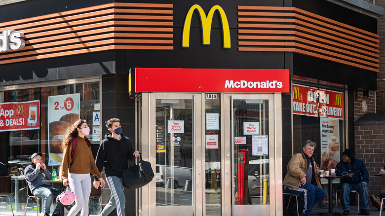 Couple in masks walking outside McDonald's restaurant