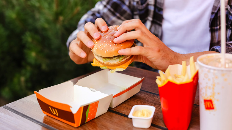 diner holding McDonald's burger