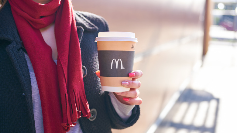 Woman wearing scarf with McDonald's coffee