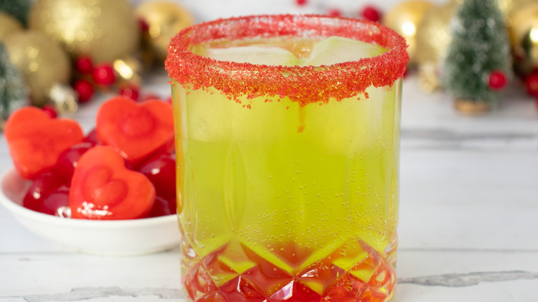 Grinch cocktail next to bowl with heart-shaped ice cubes