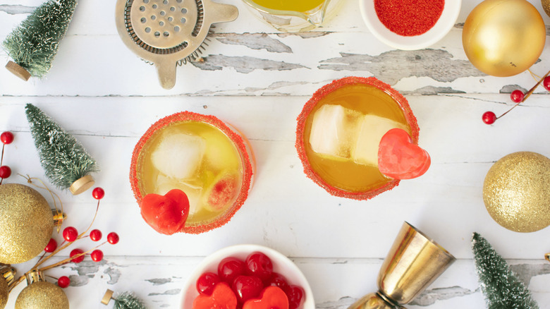 Top-down view of Grinch cocktails with various ingredients and Christmas decorations