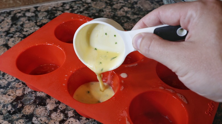 pouring egg mixture into muffin tin