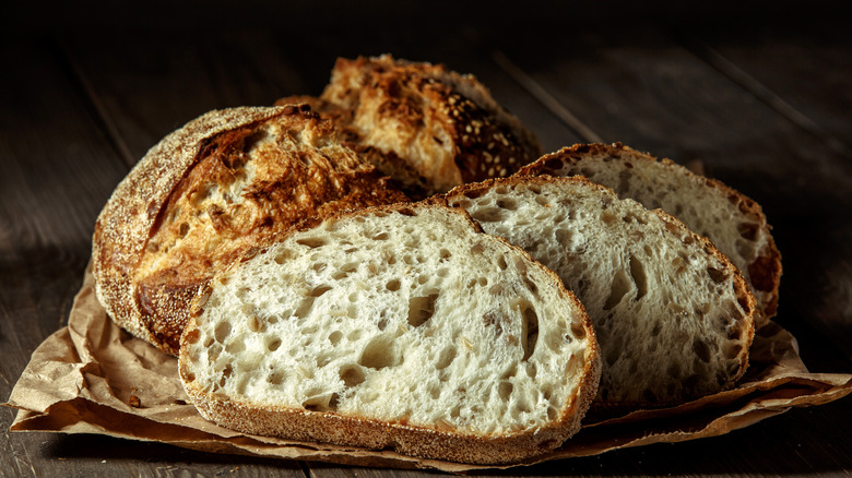 A beautiful, crusty sourdough loaf with some slices