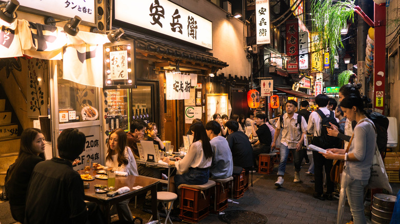 Patrons seated at food stalls in Omoide Yokocho