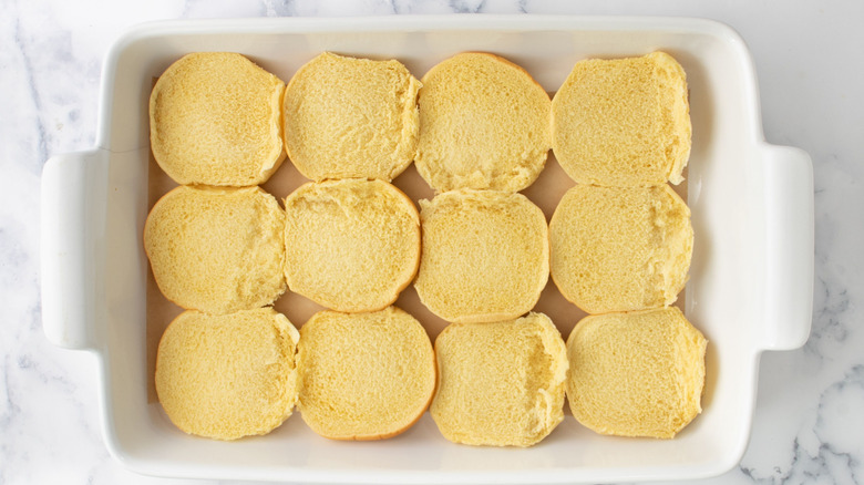 Bottom halves of slider buns in white baking dish
