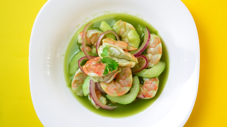 White bowl of Aguachile with yellow background