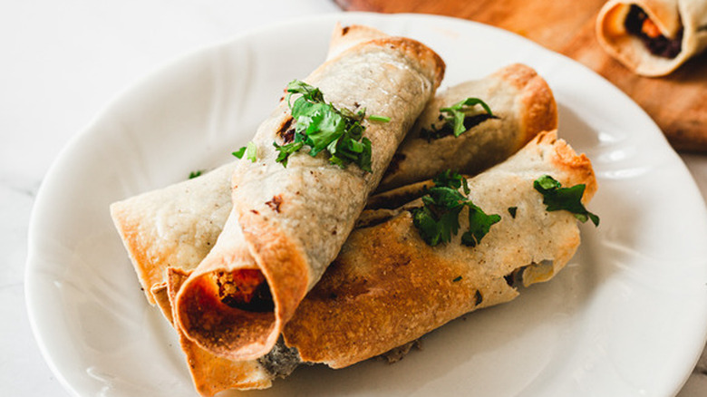 Fried taquitos on white plate