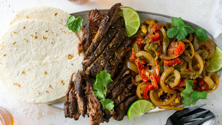 Sliced steak, cooked veggies, and tortillas