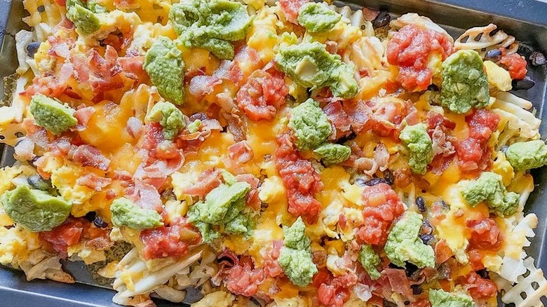 Baking sheet with egg and bacon nachos