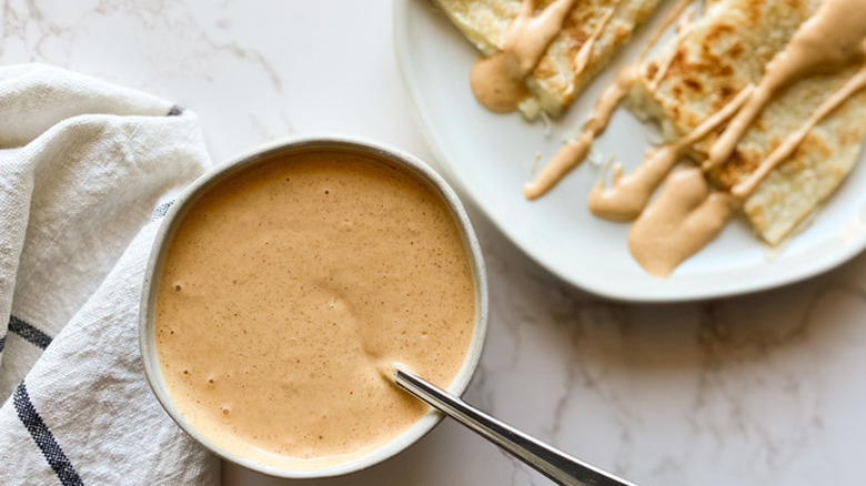 Bowl of cheese sauce with quesadillas