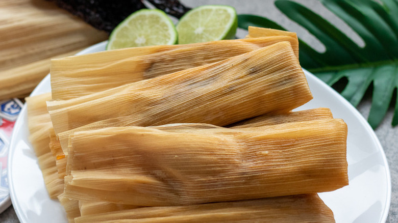 Several husk-wrapped tamales on plate