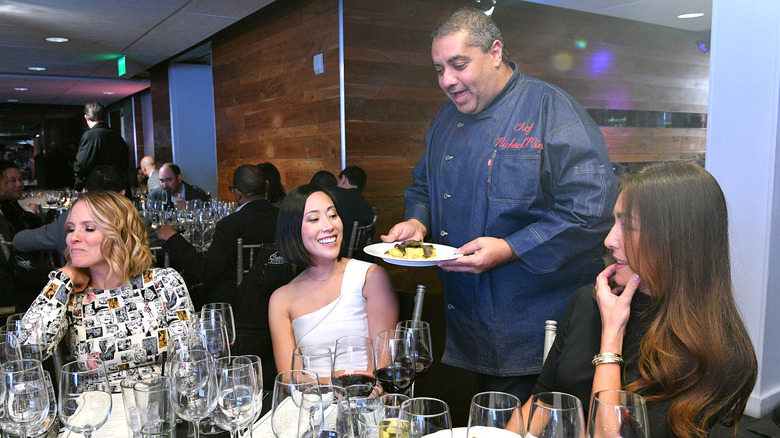 Michael Mina serves a plate of food