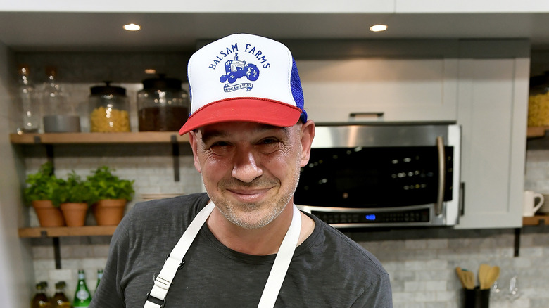 Michael Symon wearing a white baseball hat