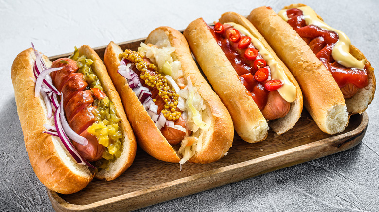 four hot dogs with toppings