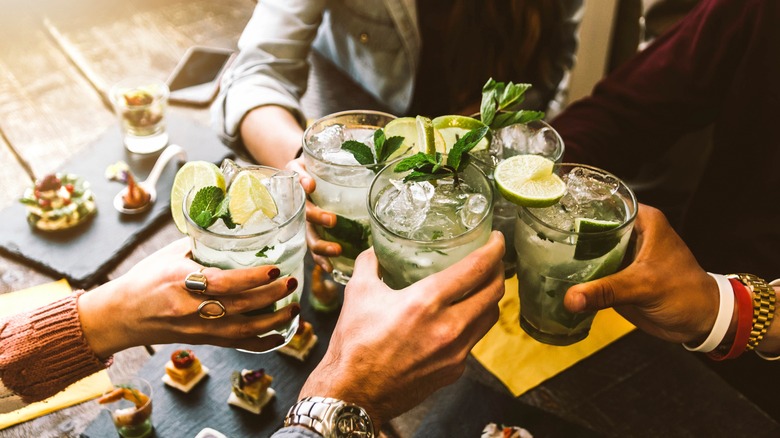 people making a toast with cocktails