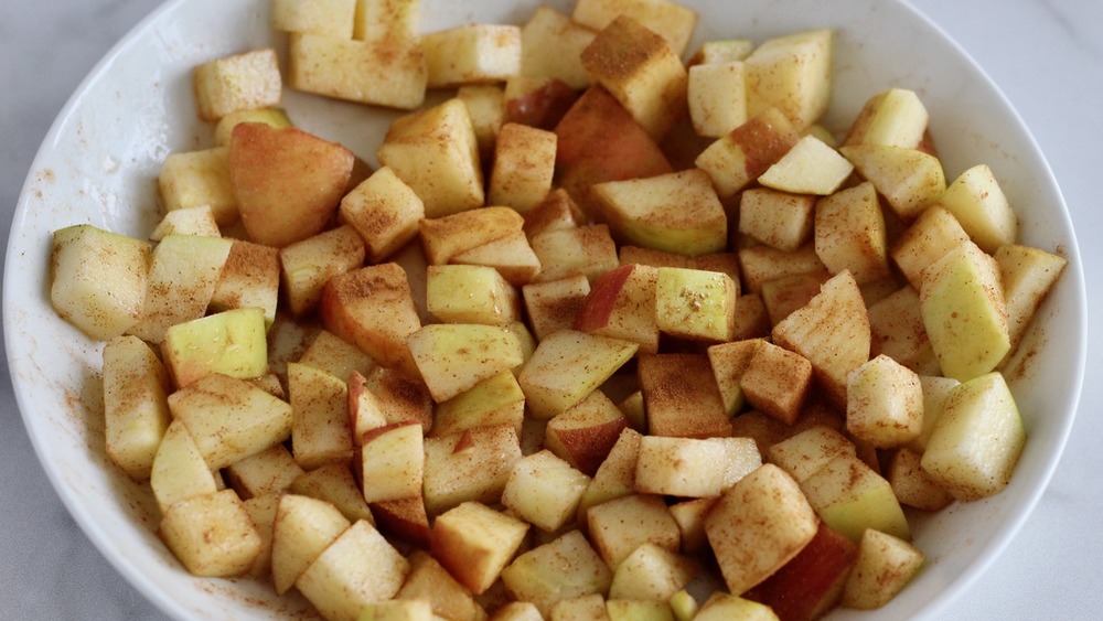 Apples with apple ingredients in a bowl for mini apple crumbles