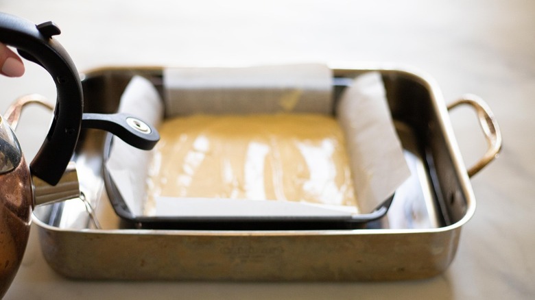 pouring water into baking pan
