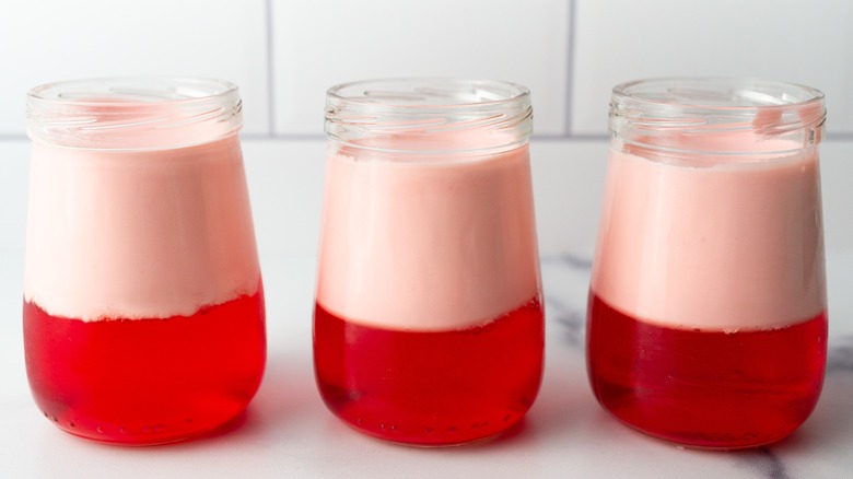 Three jello parfaits sitting on a countertop