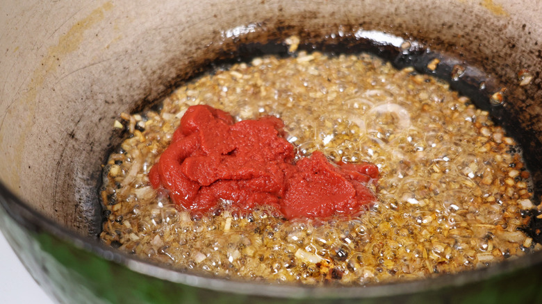 frying tomato paste with alliums