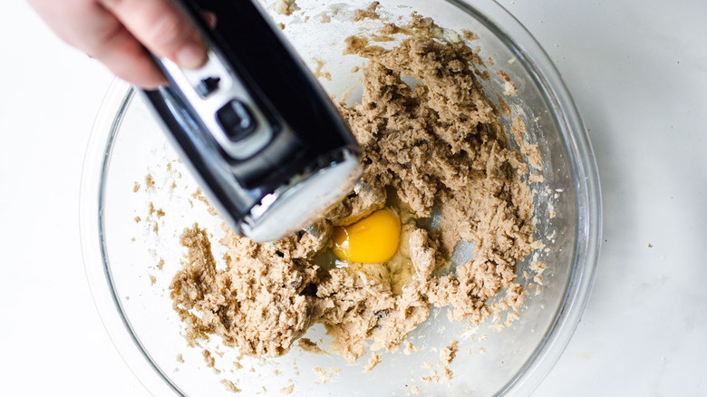  hand mixer beating an egg into sugar