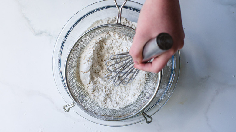 hand mixing and sifting baking ingredients