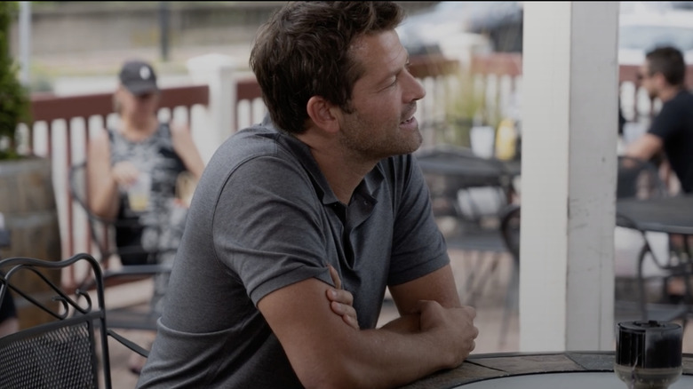 Misha Collins sitting at a table