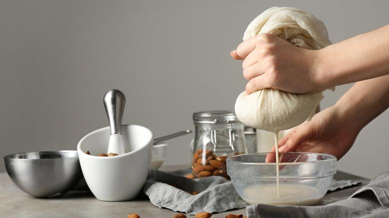 Straining almond milk over bowl