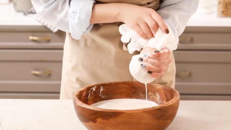 Person straining almond milk