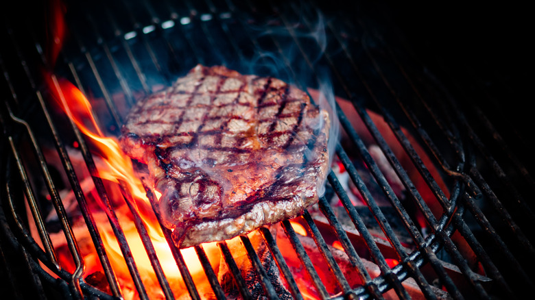 Steak cooking on charcoal grill