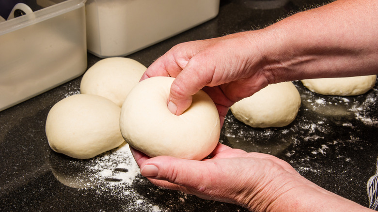 person making hole in bagel